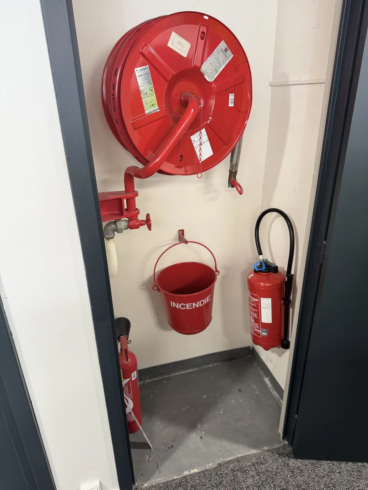 Robinet d'incendie armé, seau incendie et extincteur dans les locaux d'un client