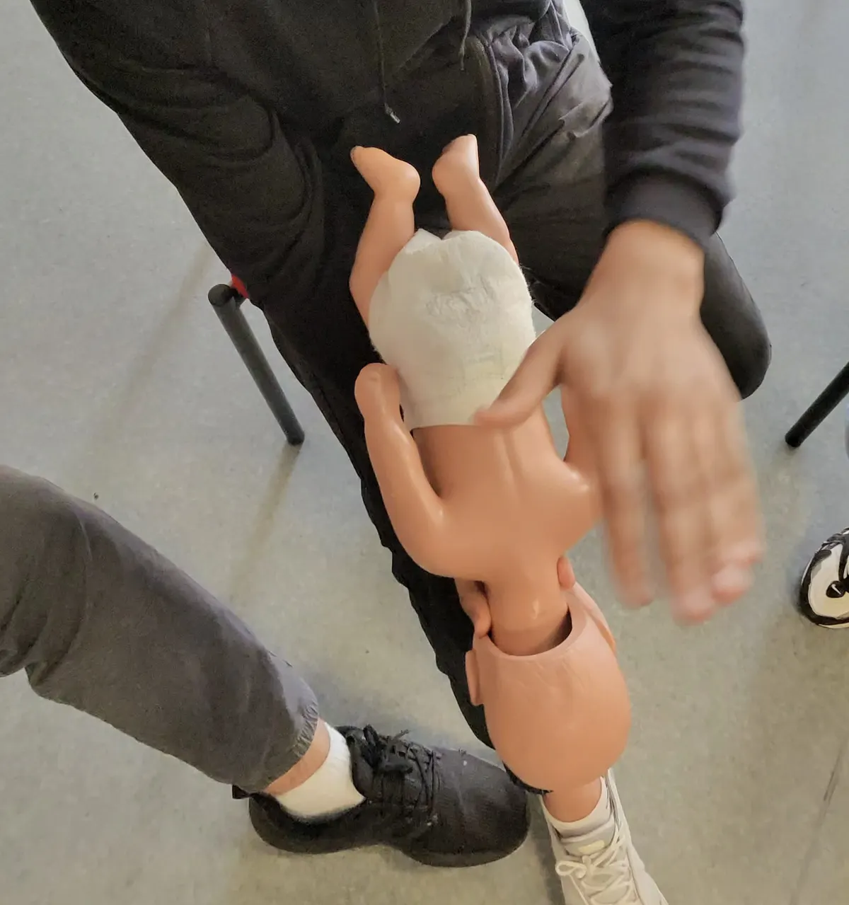 Geste de désobstruction des voies aériennes sur un mannequin nourrisson